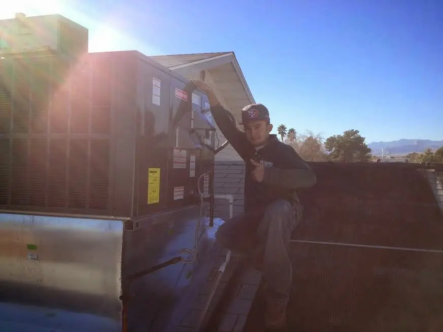 HVAC technician performing Air Duct Cleaning on a rooftop unit in Orlovista